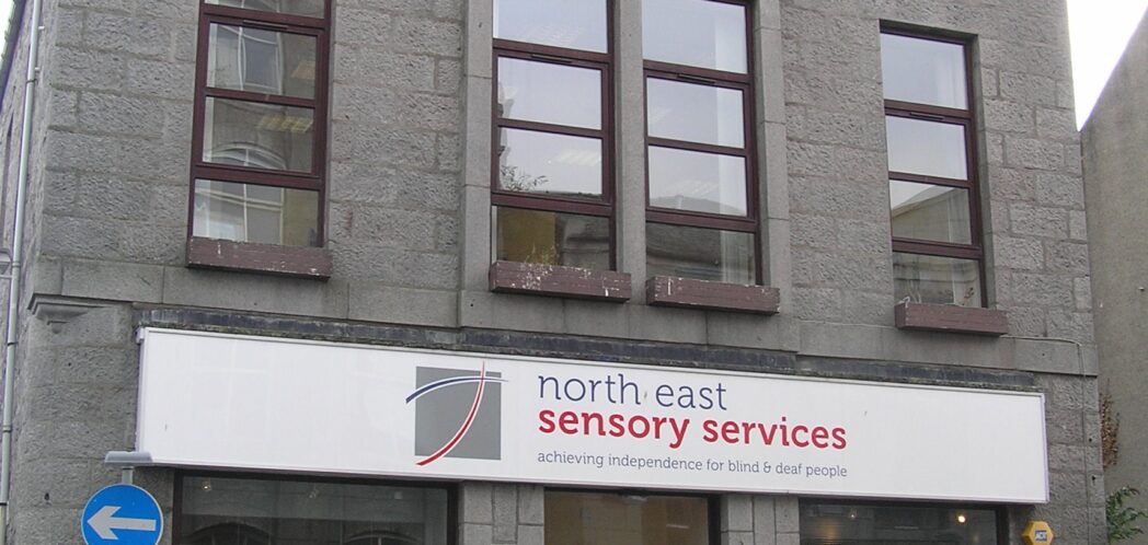 Front elevation of NESS Resource Centre on John Street, in Aberdeen. Large building, with large windows, and NESS sign over the door