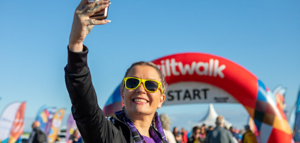 Women taking a selfie in front of Kiltwalk Start banner