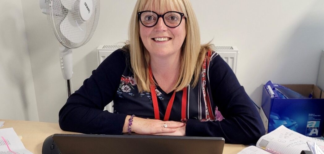 Close up of smiling Laura sitting at her desk