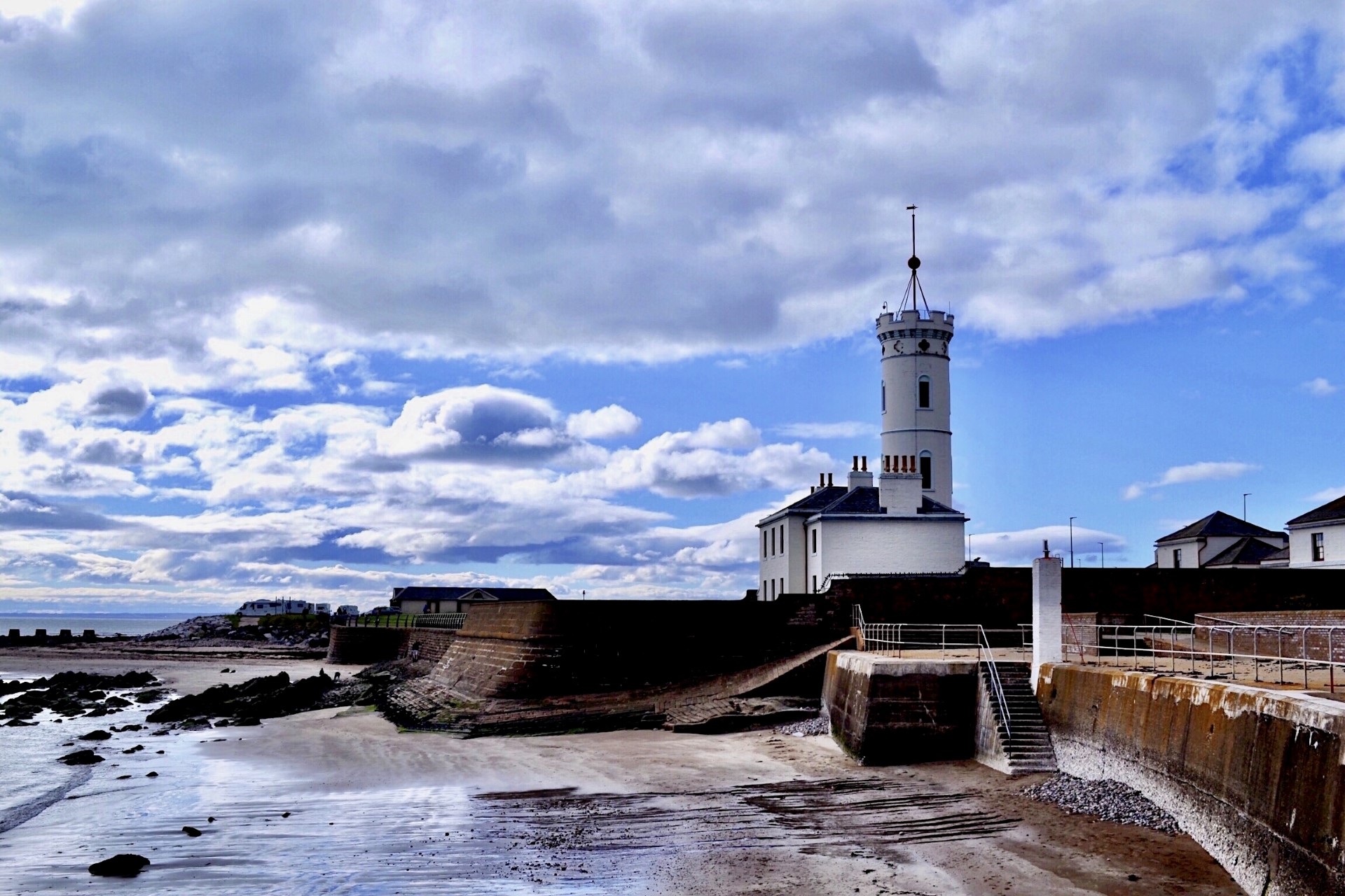 photo of signal tower on coast with beautiful clouds above