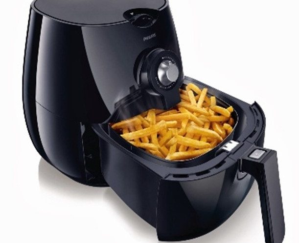 Air fryer with an open drawer full of cooked chips