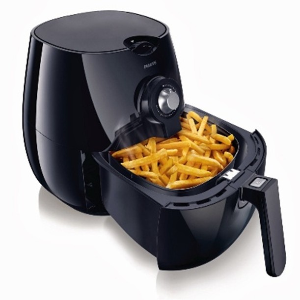 Air fryer with an open drawer full of cooked chips