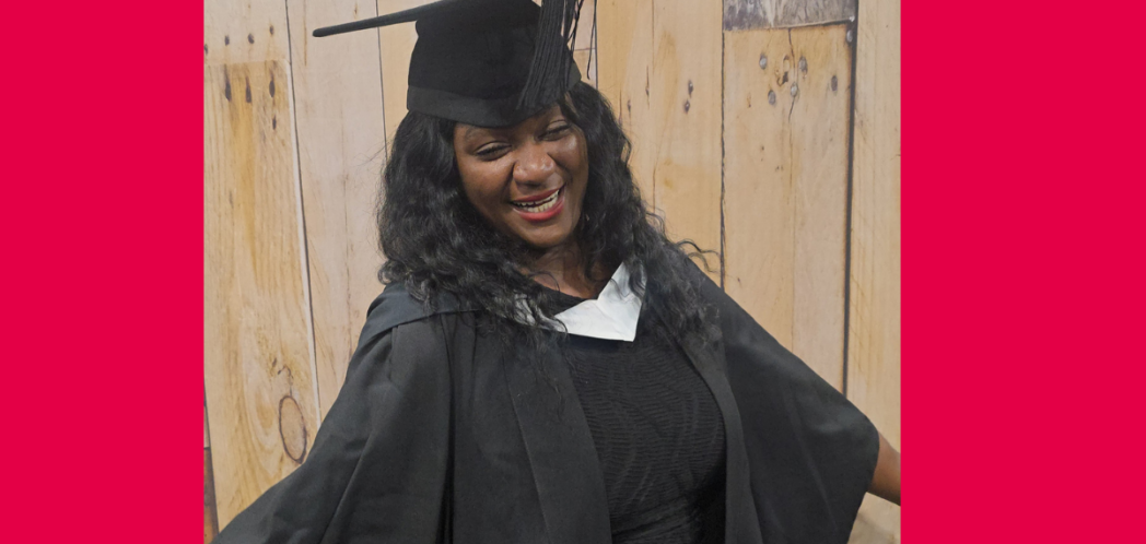 Sonia smiles wearing her graduation gown and mortar