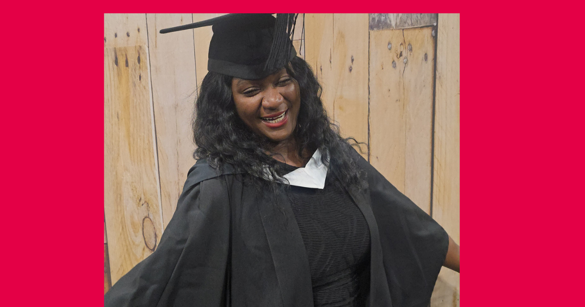 Sonia smiles wearing her graduation gown and mortar